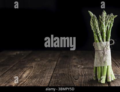 Grüner Spargel (frisch geerntet) auf einem alten Holztisch (Tiefenschärfe) Stockfoto