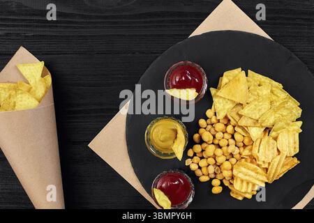 Große Auswahl an Snacks für Bier mit verschiedenen Saucen auf Pergament Draufsicht. Speicherplatz kopieren. Stillleben. Flach liegend Stockfoto