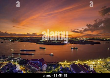 Vogelperspektive von Samut Prakan, Thailand. Sonnenuntergang über dem Fluss Chao Phraya, orangefarbener Himmel Stockfoto