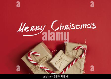 Christmas gifts on hot red background. Christmas and New Year theme. Place for your text, wishes, logo. Mock up. Top view. Copy space. Still life. Fla Stockfoto
