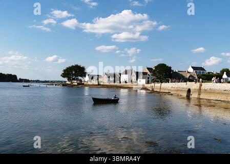 Bretagne, Frankreich - 1. August 2018: Eine ruhige Küstenszene in der Bretagne, Frankreich, mit traditioneller Architektur und einem kleinen Boot, das auf dem C schwimmt Stockfoto