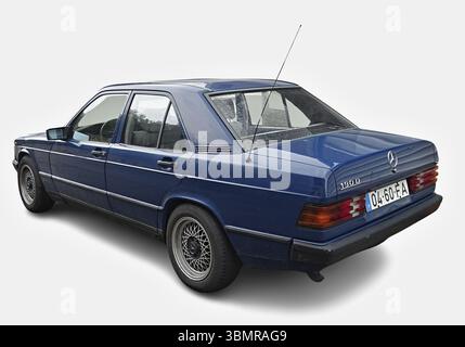 Blauer Mercedes-Benz 190er-Oldtimer auf weißem Hintergrund mit klassischem Design und zeitlosem Charme Stockfoto