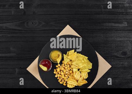 Große Auswahl an Snacks für Bier mit verschiedenen Saucen auf Pergament Draufsicht. Speicherplatz kopieren. Stillleben. Flach liegend Stockfoto