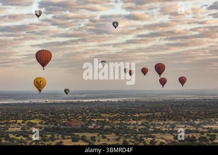 Bei Sonnenaufgang fliegen viele Ballons über das mystische Weltkulturerbe Bagan in Myanmar Stockfoto
