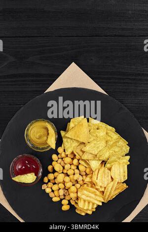 Große Auswahl an Snacks für Bier mit verschiedenen Saucen auf Pergament Draufsicht. Speicherplatz kopieren. Stillleben. Flach liegend Stockfoto