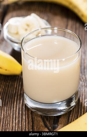 Frisch gemacht Bananensaft in einem Glas (auf hölzernen Hintergrund) Stockfoto