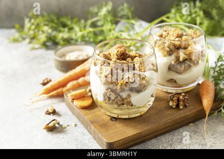 Veganes glutenfreies Backen. Karottenkuchen mit Walnüssen und Zimt in einem Glas auf hellem Hintergrund. Gesundes Dessert. Kopierbereich Stockfoto
