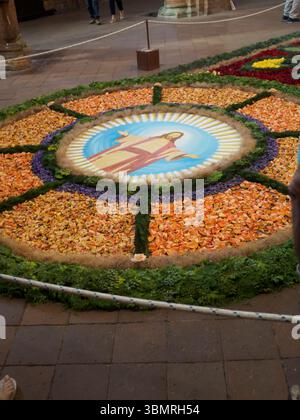 Alseno, Italien 22. Juni 2025 farbenfroher Blumenteppich, der Jesus Christus mit offenen Armen während des Fronleichnamsfestes im Zisterzienser darstellt Stockfoto