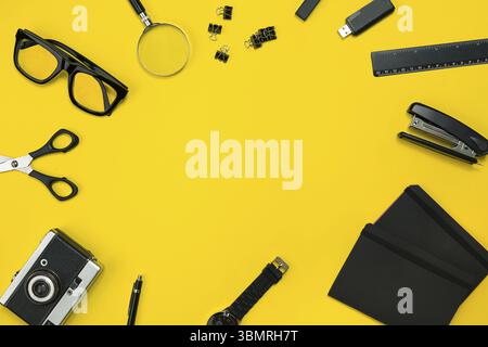 Schwarze Objekte aus dem Büro auf einem gelben Hintergrund. Arbeit und Kreativität. Social media Konzept hero Header Image. Ansicht von oben. Immer noch leben. Platz kopieren Stockfoto