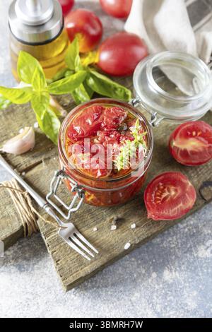 Sonnengetrocknete Tomaten im Glas mit Gewürzen und Kräutern. Gesunde hausgemachte fermentierte Lebensmittel. Hauswirtschaftslehre, Herbsternterhaltung. Kopierbereich Stockfoto