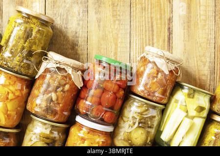 Verschiedene Arten von Gemüse in Dosen in Gläsern auf einem rustikalen Tisch. Gesundes, hausgemachtes fermentiertes Essen. Hauswirtschaft, Herbsternteerhaltung. Anzeigen Stockfoto