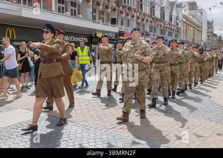 Southend on Sea, Großbritannien. Juni 2025. Militärs marschieren in Formation entlang der Southend High Street während des Armed Forces Day 2025. Die Parade mit uniformierten Mitgliedern und Kadetten war Teil einer Bürgerfeier zu Ehren der britischen Streitkräfte in Vergangenheit und Gegenwart. Die Zuschauer säumten die Straße, mit Häppchen über der Straße und kommerziellen Geschäften im Hintergrund, einschließlich McDonald's. Die Veranstaltung beinhaltete einen Danksagungsgottesdienst im Victoria Circus und markierte den 80. Jahrestag des VE und VJ Day. Parade und Feier zum Tag der bewaffneten Kräfte in der Southend High Street. Penelope Barritt/Alamy Live News Stockfoto