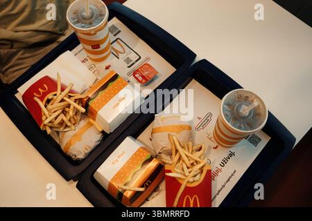 Blick von oben auf zwei Fast-Food-Tabletts mit McDonald's Big Macs, Cheeseburgern, Pommes und Getränken. Leckere Mahlzeit. Belgrad, Serbien - 7. Juni 2025 Stockfoto