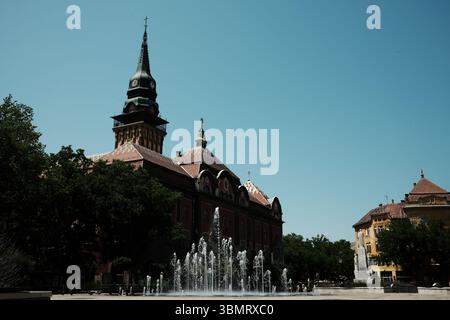 Rathaus von Subotica mit Brunnen im Vordergrund an einem klaren Sommertag, der den Charme der serbischen Architektur einfängt. Subotica, Serbien - 8. Juni 20 Stockfoto