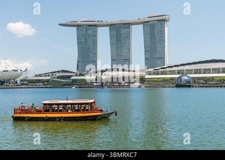 Das Marina Bay Sands Hotel und das Art Science Museum gegenüber dem Marina Reservoir mit einem Touristenboot, Singapur Stockfoto