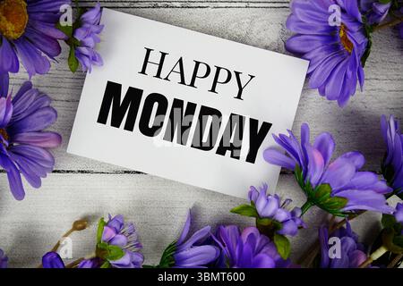 Happy Monday Text mit Blumendekoration auf hölzernem Hintergrund Stockfoto