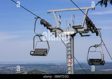 Nahaufnahme des Mechanismus des Skiliftstuhls mit Seilstützturm und Seilrollensystem. Infrastruktur des Bergverkehrs und technische Technik Stockfoto