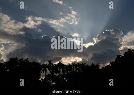 Sonnenstrahlen, die bei Sonnenuntergang durch die Wolken brechen Stockfoto