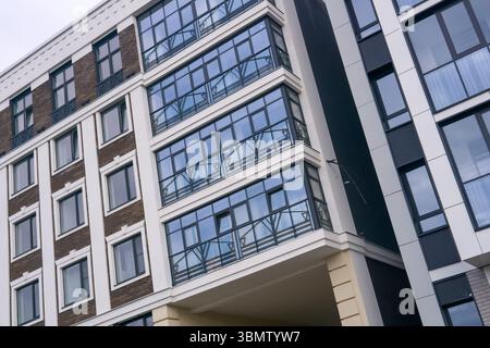 Modernes Apartmentgebäude mit Glasfassade. Architektonische Details eines modernen Gebäudes Stockfoto