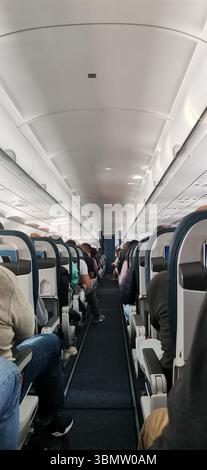 Flugzeugkabine mit Personen. Passagiersitz, Flugzeuginnenraum mit Passagieren auf den Sitzen. Reisekonzept. Stockfoto