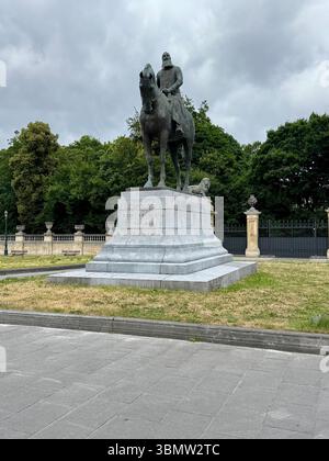 Reiterstatue von König Leopold II. In Brüssel, Belgien, stehend auf einem Steinpodest in einem Stadtpark unter bewölktem Himmel. Stockfoto