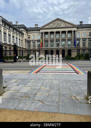 Vorderansicht des belgischen Bundestagsgebäudes in Brüssel mit einem regenbogenbemalten Quersteg, der den Stolz und die Inklusivität von LGBTQ+ symbolisiert. Stockfoto