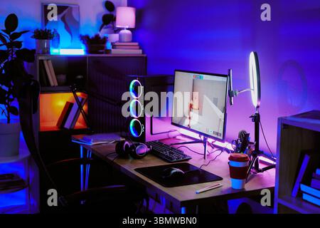 Moderne Gaming-Einrichtung mit Streaming-Ausrüstung im Schlafzimmer für Teenager bei Nacht Stockfoto
