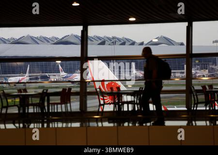 Kuala Lumpur, Malaysia - 6. Dezember 2022: Silhouette eines Passagiers, der durch den internationalen Flughafen KLIA läuft. Batik Malindo und Malaysia Airlines. Stockfoto