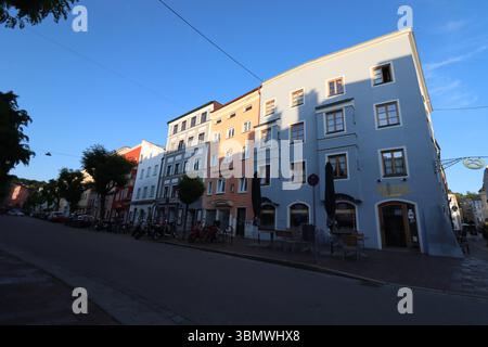 WASSERBURG AM INN, DEUTSCHLAND - 20. JUNI 2025: Bunte Wohnhäuser in der Abendsonne entlang einer ruhigen Straße im historischen Stadtzentrum Stockfoto