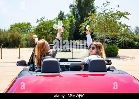 Freundinnen in einem Cabrio werden die Freiheit feiern. Rückansicht eines Cabrios mit Mädchen Stockfoto