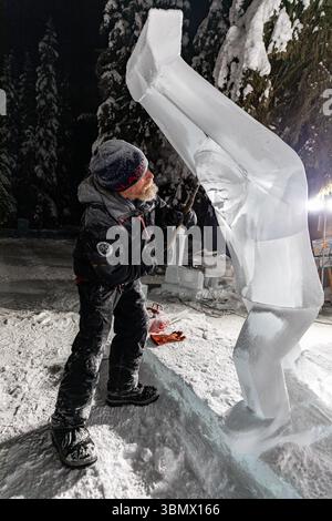 Fairbanks, USA - 21. Februar 2023: Künstler arbeitet nachts an Eisskulptur für Eiskunstweltmeisterschaften, Eisskulpturwettbewerb und -Festival Stockfoto
