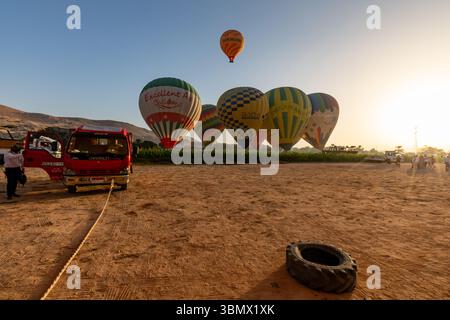 Eine Gruppe von Heißluftballons macht sich auf den Weg zu einer Luftfahrt bei Sonnenaufgang durch das Tal der Könige, Luxor, Ägypten Stockfoto