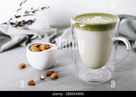 Stillleben, Glas Grüntee Matcha Latte mit Mandeln Stockfoto