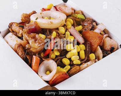 Stillleben, gebratene Nudeln mit Meeresfrüchten und Gemüse im asiatischen Stil Stockfoto