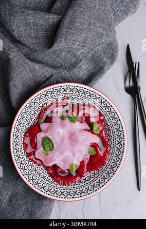 Stillleben, vegane rote Ravioli mit Roter Bete auf einem Teller in Sahnesauce Stockfoto