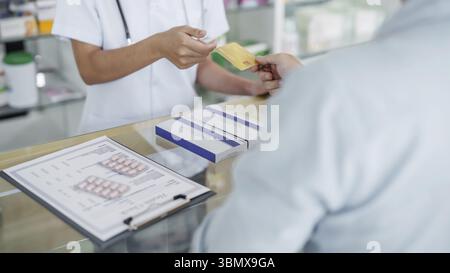 Kunde an der Kasse, um Medizin bei einem Apotheker in der Apotheke zu kaufen Stockfoto