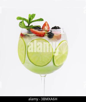 Essen Stillleben, trinken mit Beeren, mit Limettenscheiben und Minze in einem Weinglas Stockfoto