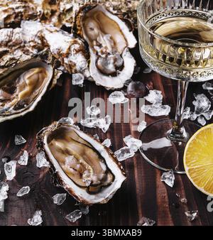 Stillleben, frische Austern und Weinglas mit Eiswürfeln Stockfoto