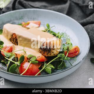 Stillleben, gegrilltes Lachsfilet mit Spinat und cremiger Sauce Stockfoto