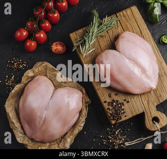 Stillleben, rohe Hühnerfilets auf hölzernem Schneidebrett, Draufsicht Stockfoto