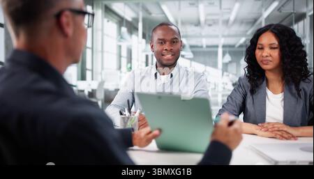 Immobilienmakler Berät Glückliches Paar Über Laptop Für Neues Zuhause. Stockfoto