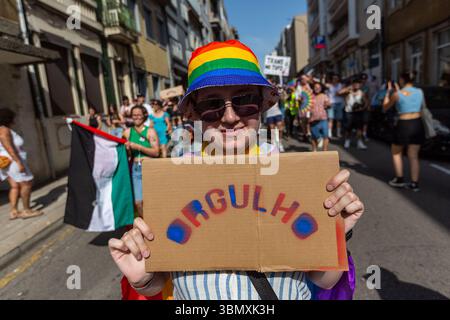 Ein Teilnehmer hält während des 20. LGBTI+ Pride March ein Pappschild mit dem Wort „Orgulho“ („Pride“) in Regenbogenfarben. Mit einem leuchtenden Regenbogenhut stehen sie inmitten einer bunten Menschenmenge, die Sichtbarkeit, Identität und Widerstand im Herzen der Stadt zelebriert. Stockfoto
