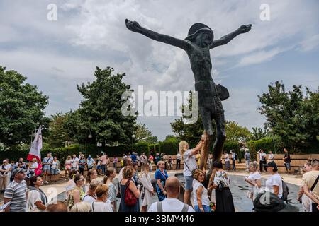 Pilger versammelten sich an der Statue des auferstandenen Christus im Komplex der St. Jakobskirche in Medjugorje. Stockfoto