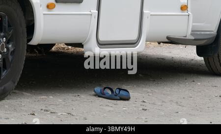 Paar Sandalen in der Nähe eines Freizeitfahrzeugs Stockfoto