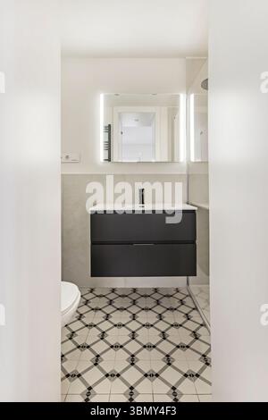 Wasserhähne, oft in die Wand eingebaut oder mit minimalistischem Design, werden zu einem skulpturalen Detail, das das ganze ergänzt. Stockfoto
