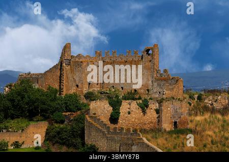 Das Castello del Rivellino oder Rivellino Castle, ein befestigter Palast aus der Mitte der 1200er Jahre, der auf einer etruskischen akropolis erbaut wurde, war einst das Zentrum der bürgerlichen und justiziellen Macht in der Toskana, Latium, Italien. Die Ruinen stehen inmitten der viel älteren etruskischen und römischen Überreste der Stadt Tuscana, die im 7. Jahrhundert v. Chr. gegründet wurde. Stockfoto