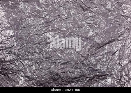 Es ist ein schwarzer, zerknitterter Papierhintergrund. Stockfoto