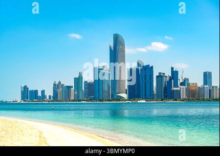 Abu Dhabi, Panoramablick mit Meer und Wolkenkratzern an sonnigen Tagen Stockfoto