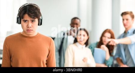Die Leute spotten und machen sich über traurigen asiatischen Mann lustig Stockfoto