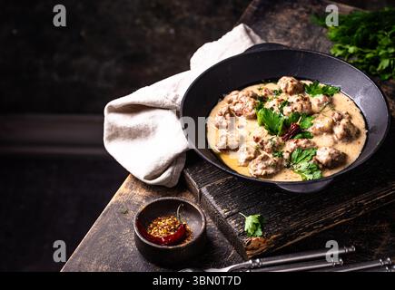 Fleischbällchen in Sauerrahmsauce in einer Pfanne Stockfoto